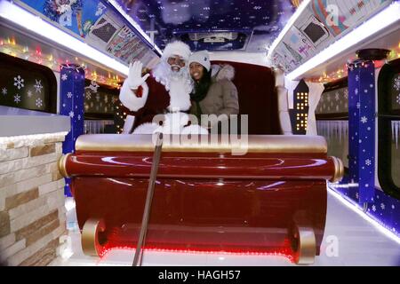 Chicago, USA. 30. November 2016. Foto aufgenommen am 30. November 2016 zeigt einen Mitarbeiter als Weihnachtsmann verkleidet posiert mit einem Passagier in einem Weihnachts-Bus am Jefferson Transit Center in Chicago, USA. Anlässlich die bevorstehende Weihnachtszeit eingeführt Ferienzeit, die Chicago Transit Authority (CTA) Weihnachten Bus-Service, die bestimmte Route durch die Stadt läuft. Bildnachweis: Wang Ping/Xinhua/Alamy Live-Nachrichten Stockfoto