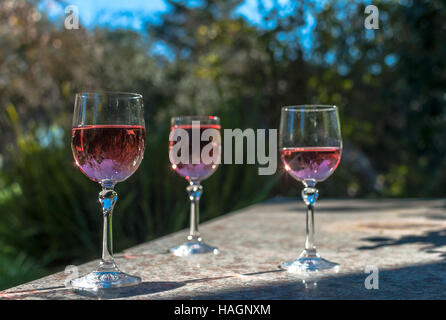Rosè Weine in Stielgläser auf einem Tisch in einem Garten an einem sonnigen Tag Stockfoto