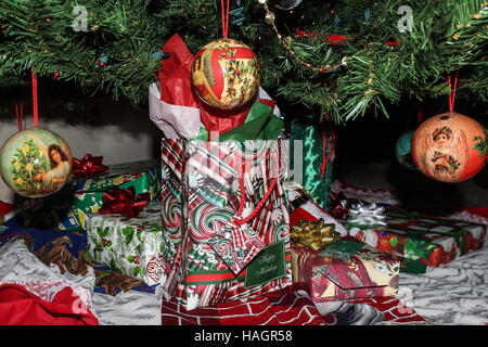 Nahaufnahme der Heimat verpackte Geschenke für den Urlaub in bunten Kisten und Säcke unter dem Baum mit Engel Verzierungen in den Vordergrund. Stockfoto