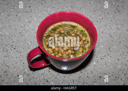 Tasse nahrhafte Linsensuppe mit Spinat und fleischlose zerfällt in einer Brühe Gemüse und Bier Stockfoto