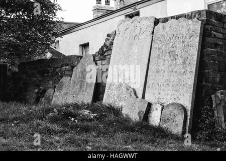 Lehnt an der Wand auf dem Friedhof Grabsteine gebrochen Stockfoto