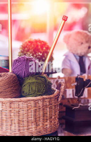 Stricken Garn Kugeln und Nadeln in Korb Stockfoto