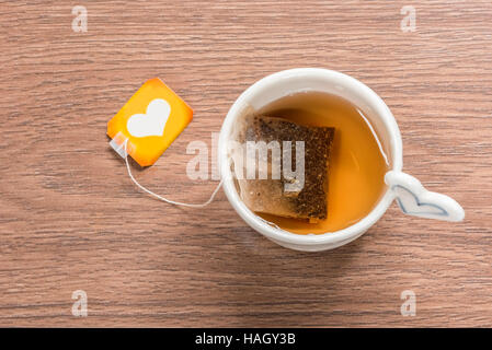 Tasse Tee mit Teebeutel auf hölzernen Hintergrund Stockfoto
