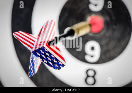 Dart Pfeil mit Usa Flagge schlagen in der Ziel-Mitte der Dartscheibe, flachen DOF Stockfoto