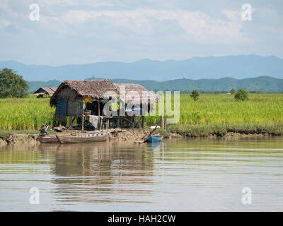 Traditionelle Bauernhäuser aus Stroh entlang des Flusses Kaladan im Rakhine-Staat von Myanmar gemacht. Stockfoto