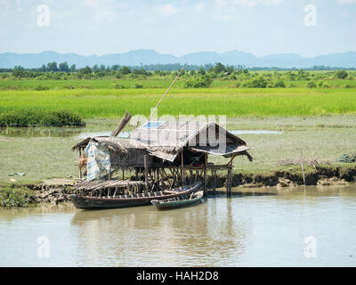 Sehr einfache, traditionelle Bauernhaus aus Stroh, sondern mit einem Sonnenkollektor auf dem Dach für Strom, in Myanmar. Stockfoto