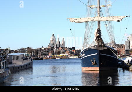 Amsterdam historische Skyline mit 19. Jahrhundert Basilika von St. Nicholas katholische Kirche in Amsterdam. Segelschiff im Vordergrund. Stockfoto