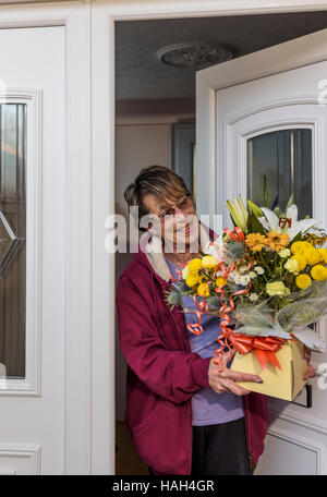 Ältere Dame die Annahme einer blumenlieferung am Muttertag oder Geburtstag. Stockfoto