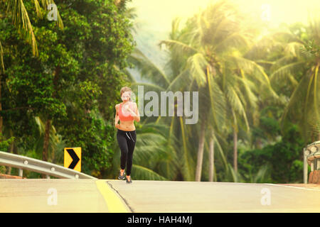 junge Fitness Frau läuft im tropischen Wald Stockfoto