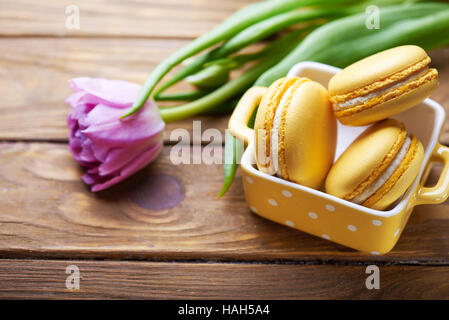 Makronen und lila Tulpe auf Holztisch Stockfoto