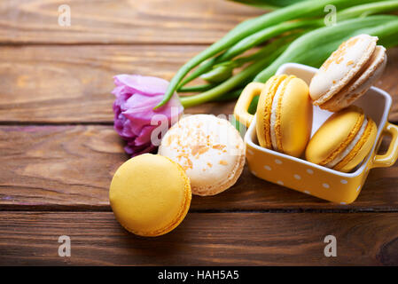 Makronen und lila Tulpe auf Holztisch Stockfoto