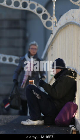 Ein Mann betteln auf Dublins Ha'penny Brücke als neuesten zeigen offiziellen Zahlen einen 56 % Anstieg der Zahl auf den Straßen der Hauptstadt seit letztem Winter schlafen. Stockfoto