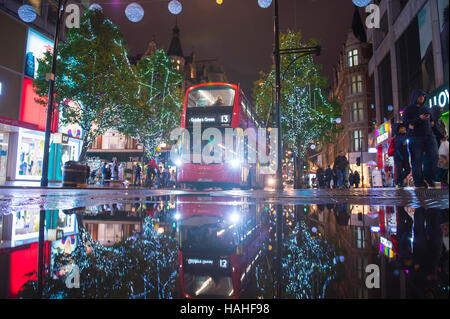 LONDON - 16. November 2016: Roten Doppeldecker-Bus mit Urlaub Lichter reflektiert, wie Fußgänger drängen sich Oxford Street. Stockfoto