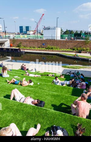 Sonnenanbeter auf der künstlichen - begrünt Schritte der Getreidespeicher Square von Regent's Canal während der Sanierung von King's Cross, London, UK Stockfoto