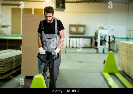 Junger Arbeitnehmer arbeitet in einer Fabrik für die Herstellung von Möbeln Stockfoto