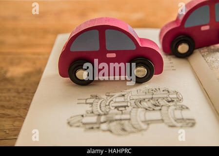 hölzernes Auto. Offenes Buch mit Zahnrad-Schema. Umweltfreundliche Welt. Foto von Ökologie das Konzept des modernen Designs Infografiken. das Symbol einer Stockfoto