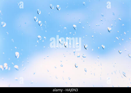 Wassertropfen auf Glas gegen blauen Himmel Stockfoto