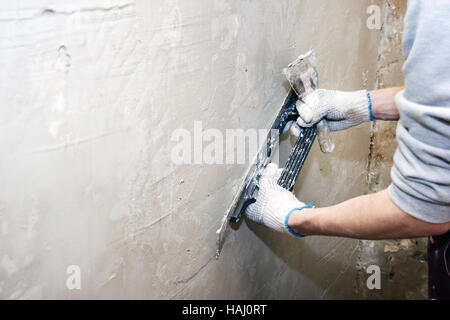 Arbeit ausrichtet. Putz aufstellen an der Wand, mit Spachtel Stockfoto