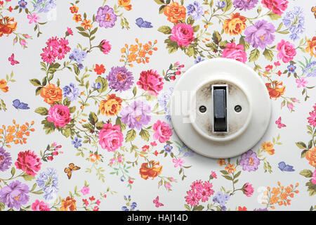 alte Lichtschalter auf Vintage floral Tapete Stockfoto