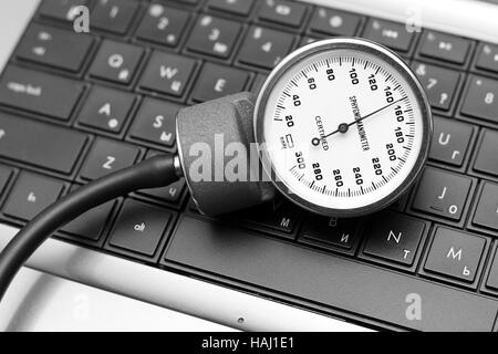 Blutdruckmessgerät auf Laptop-Tastatur Stockfoto