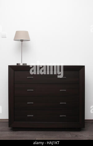 braune Kommode mit Lampe innen hell Minimalismus Stockfoto