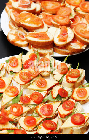 verschiedenen köstlichen Häppchen mit Käse Lachs und Tomaten Stockfoto