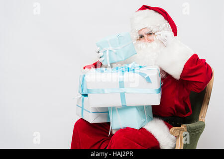 Foto von happy Santa Claus mit Giftboxes Blick auf Sie Stockfoto