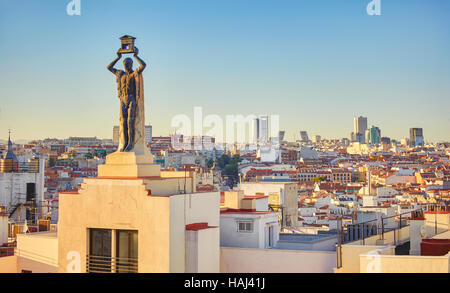 'Der Roman' Skulptur (1930), von Victorio Macho, an der Spitze der 60 Gran Via Street Building und Skyline von Madrid gelegen. Madrid. Spanien. Stockfoto