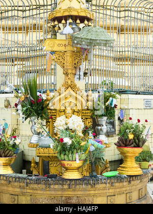 Buddha Statue geschmückt mit Blumen an die Botahtaung Pagode in Yangon, Myanmar Stockfoto