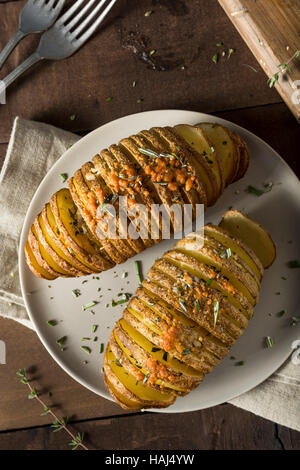 Hausgemachte kitschig Hasselback Kartoffeln mit frischen Kräutern Stockfoto