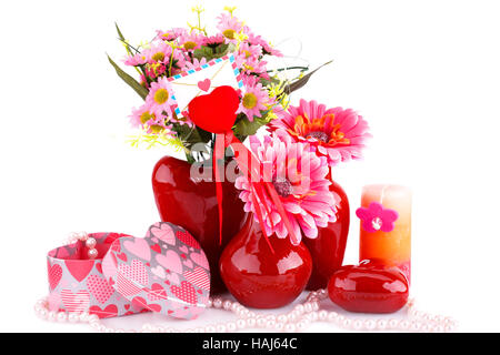 Blumen in Vasen, Glas rotes Herz, Halskette, Geschenkboxen und Kerze isoliert auf weißem Hintergrund. Stockfoto