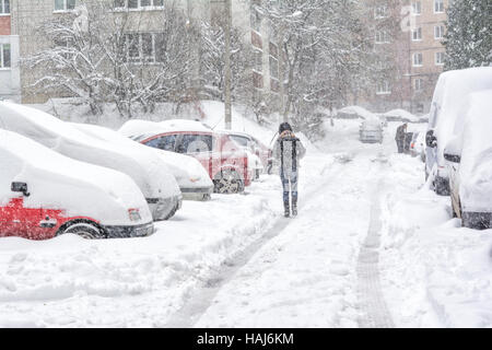 Schneesturm in Lemberg, Ukraine im 13. November 2016. Schneebedeckte Straße und Autos mit einem einsamen Fußgänger Stockfoto