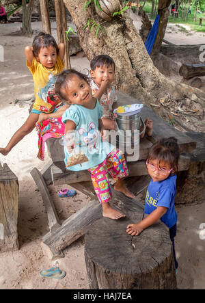 Vier Glückliche kambodschanische Kinder teilen sich einen Snack zusammen in Banteay Srei in der Nähe von Siem Reap, Königreich Kambodscha. Stockfoto