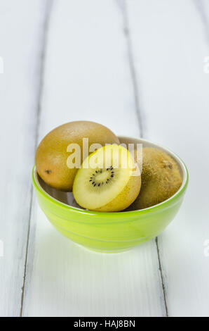 Kiwi-Früchte in einer Schüssel auf hölzernen Hintergrund Stockfoto