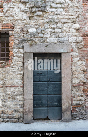 In Italien alte zerschlagenen Türen geben oft weg in Plüsch und modernen Wohnungen. Reichtum ist nicht eine nach außen zeigen. Lucca Stadt Türöffnung, Lucca, Toskana, Italien Stockfoto