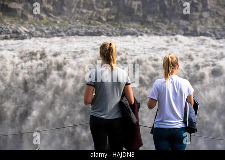 zwei Touristen beobachten Dettifoss-Wasserfall in Island Stockfoto