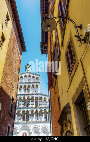 Blick durch eine Gasse auf die Kirche San Michele in Foro in Lucca, Italien Stockfoto