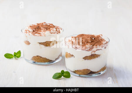 Hausgemachte Tiramisu Dessert im Glas auf weißer Holztisch Stockfoto