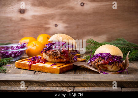 Hausgemachte Bbq Beef-Burger mit knackigem Rotkraut Slaw auf rustikalen Tisch. Grill Fleisch Sandwiches zum Weihnachtsessen Stockfoto