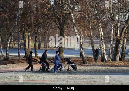 Golfer finden ihren Weg auf eine Frost bedeckt Fairway im Hartley Wintney Golf Club in Hampshire, mit dem heutigen Tag markiert den offiziellen Beginn der meteorologischen Winter Temperaturen unter dem Gefrierpunkt wieder über weite Teile von England und Wales wieder gesunken. Stockfoto