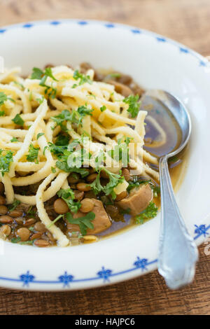 Linsensuppe mit Spätzle und vegane Bratwürste Stockfoto