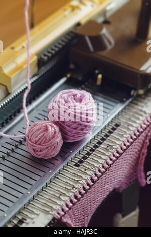 Hand-Strickmaschine. Eine Strickmaschine ist ein Gerät zur Erstellung von Gewirke in einem halb- oder vollautomatischen Mode. Stockfoto