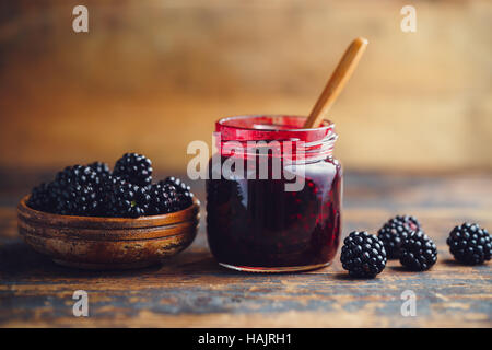 Frische hausgemachte Brombeermarmelade in Glas auf einem hölzernen Hintergrund Stockfoto