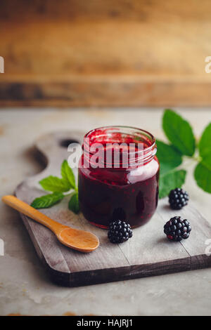 Frische hausgemachte Brombeermarmelade in Glas auf einem hölzernen Hintergrund Stockfoto