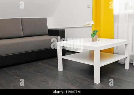 helle Wohnung Interieur mit Sofa, Couchtisch und gelbe Vorhänge Stockfoto