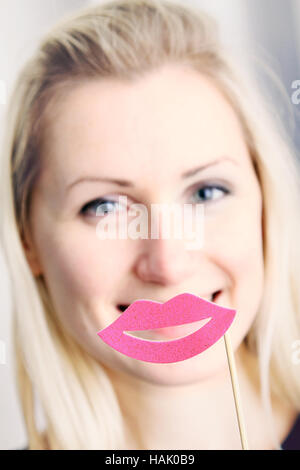 lächelnde Frau mit großen Lippen vor den Mund Stockfoto