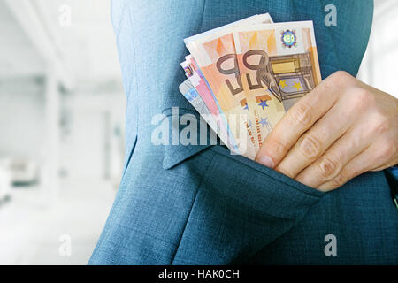 Korruption-Konzept, Mann, Geld in die Jackentasche Stockfoto