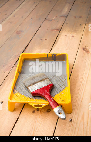 Holzbrett Boden lackieren. grauen Lack und Pinsel im tray Stockfoto