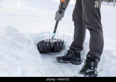 Schneeräumung mit einer Schaufel aus Bürgersteig nach blizzard Stockfoto