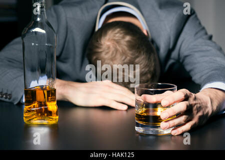 Alkoholsucht - betrunken Geschäftsmann mit einem Glas Whisky Stockfoto